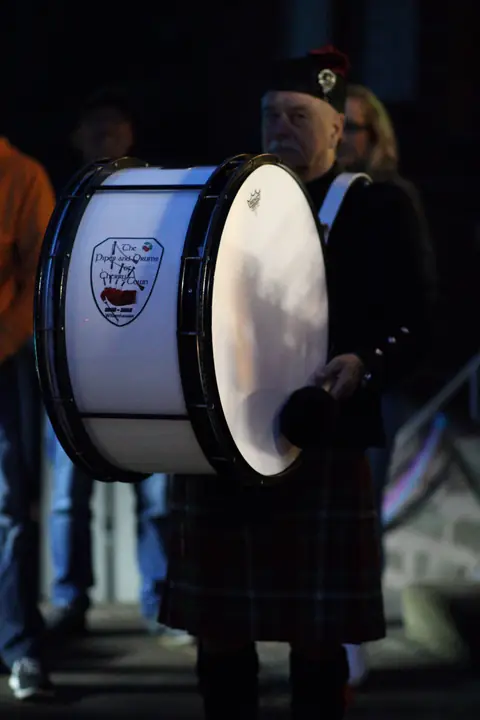 Bass-Drummer der Pipeband mit großer Trommel bei einem Abendauftritt