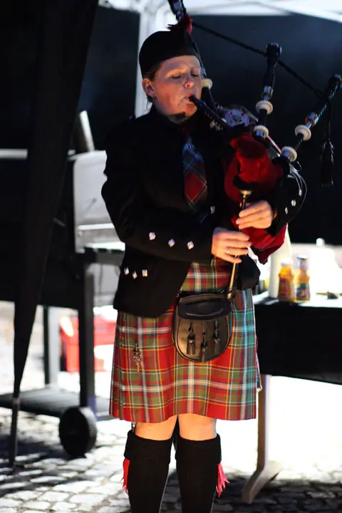 Dudelsackspieler in schottischer Tracht mit Kilt im Drummond-Tartan und Sporran